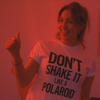 Frau trägt T-Shirt mit der Aufschrift Don`t shake it like a polaroid
