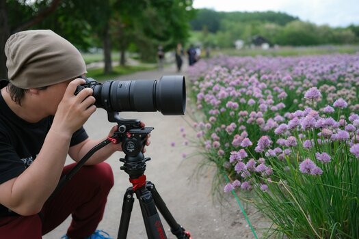 Fotograf(in) bei Makroaufnahme von Blumen oder blühenden Gräsern mit dem TAMRON 150-500mm F/5-6.7 Di III VC VXD an X-Mount-Kamera auf Stativ