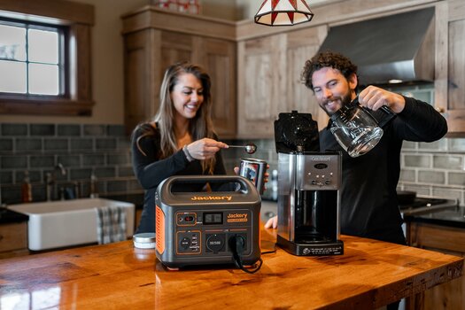 Paar in der Küche beim Kaffeekochen. Die Kaffeemaschine wird über den jackery Solargenerator Explorer 1000 betrieben.