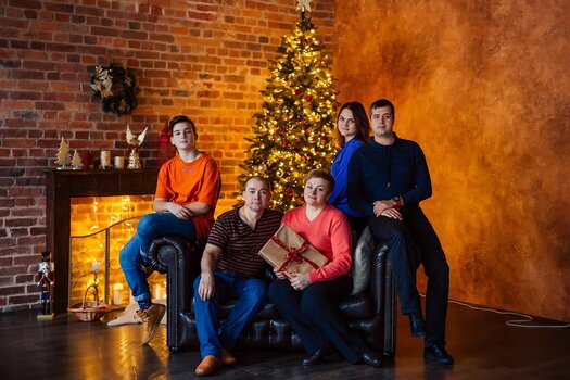 Familienportrait vor Kamin und Weihnachtsbaum