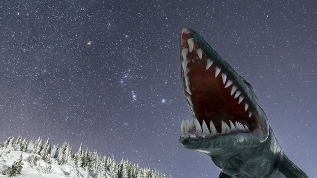 Figur eines Sauriers mit aufgerissenem Maul und spitzen Zähnen vor schneebedecktem Wald und Sternenhimmel