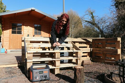 k1_5_Abschleifen einer Holzbank im Garten. Schleifgerät betrieben mit Jackery Solargenerator.jpg