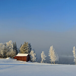 Minus 30 Grad an einem winterlichen Morgen in Schweden - das eiskalte Wasser dampft und zaubert den Nebel und den Reif zu dieser Winterlandschaft zusa