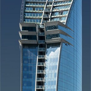 Das W-Hotel in Barcelona - an der rechten Fassade geht ein Fensterputzer seiner "Lebensaufgabe" nach. In den oberen, rechten "Erkerfenstern" spiegelt 
