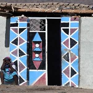 Die Eingangstür ist im Sudan etwas ganz besonders.
Jede Tür ist anders und immer bunt dekoriert

s760 Sessabi Frau Tür 5355