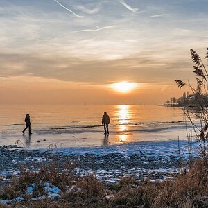 Winter am Bodensee

Spaziergänger genießen den Sonnenuntergang am gefrorenen Uferbereich