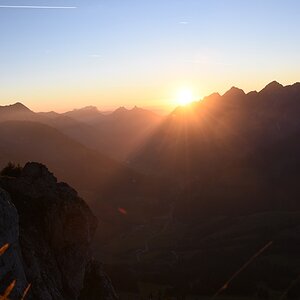 Sonnenuntergang über den Freiburger Voralpen. Unnatürliches rotes Band um die Sonne.