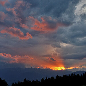 Sonne hinter Bergen und Wolken
