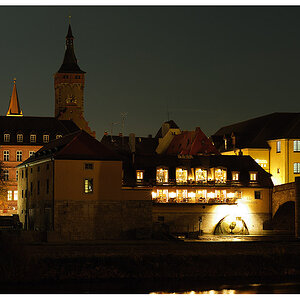 Das Bild zeigt die alte Mainmühle an der Würzburger Schleuse. Im Hintergrund erkennt man den Turm vom Rathaus.