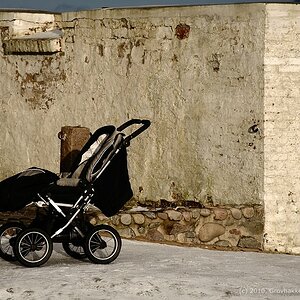 Verlassener Kinderwagen am Gemäuer