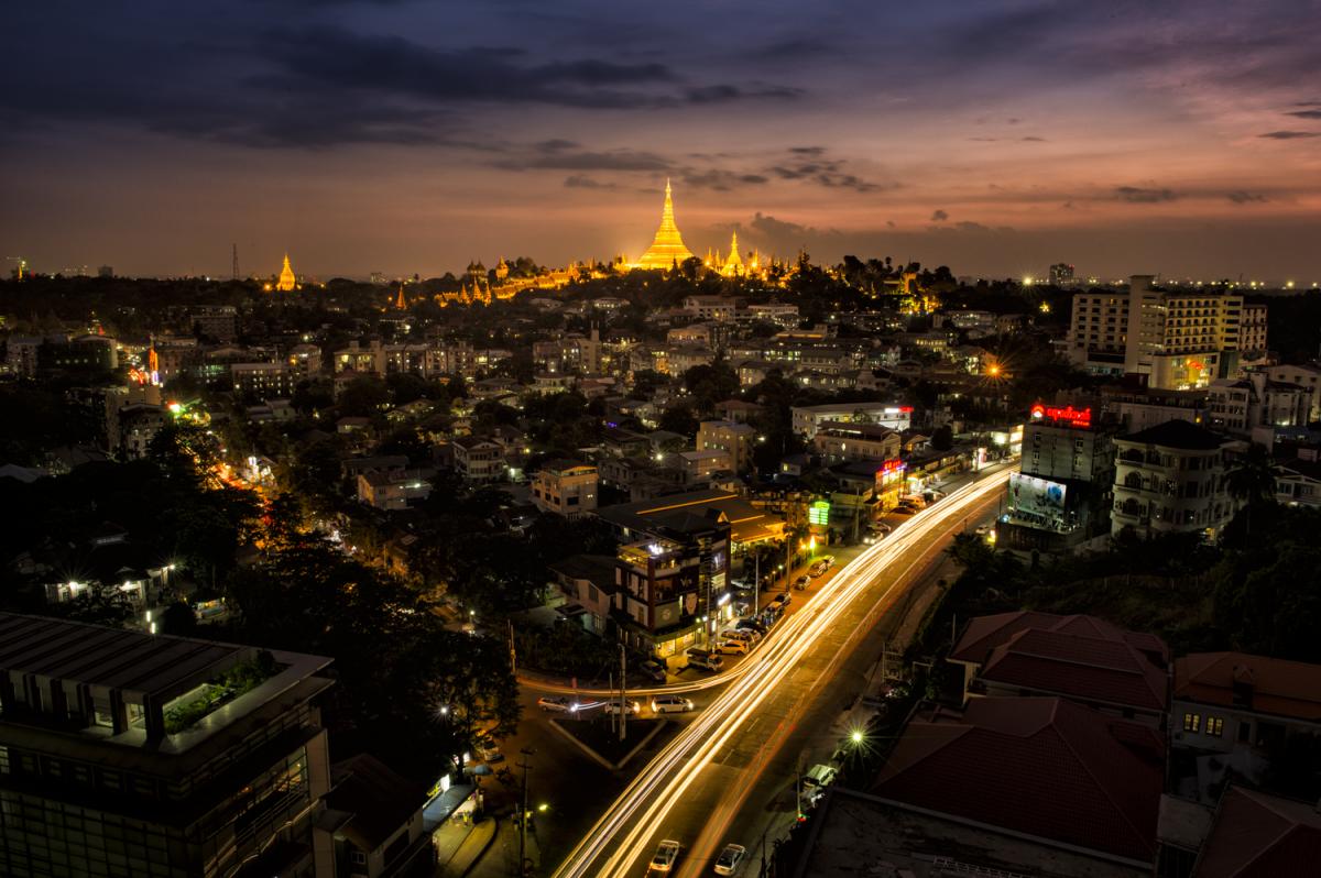 Above all - Der Blick auf die fantastische Shwedagon Pagode in Yangon, nachts von einem Häuserdach.