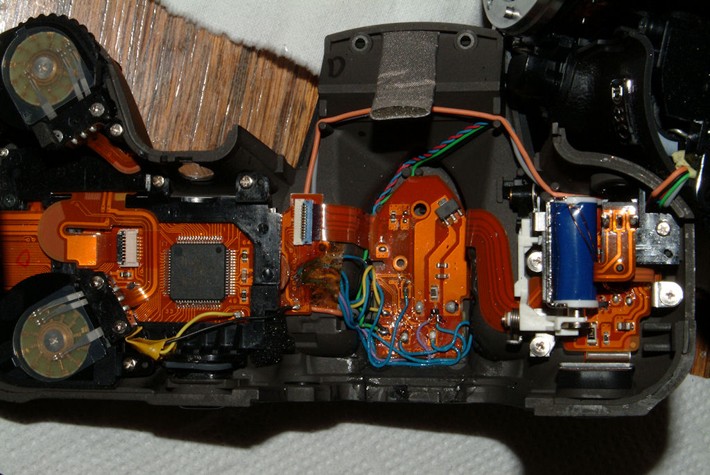 D80 mit defektem AE-L/AF-L-Knopf, am Blitzschuh zerbrochenem Oberteil und Abriss der Leiterbahnen: Oberteil geklebt, alle Kontakte wieder verbunden, A