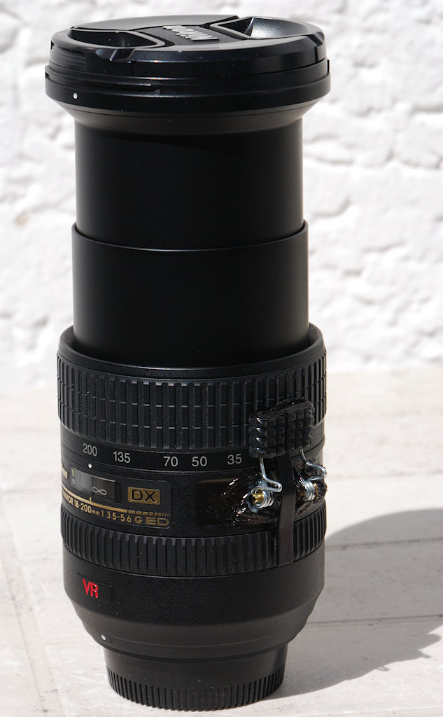 Die selbst gebastelte Klemme gegen den Zoom Creep
meines alten 18-200/3.5-5.6G IF-ED VR Nikkors hält...
