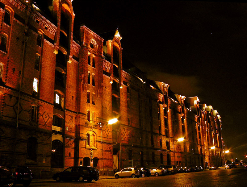Hamburger Speicherstadt bei Nacht.
Die Speicherstadt mit ihren rund 25 Hektar Fläche (einschliesslich der Fleete) ist heute eine der Länge nach – im W