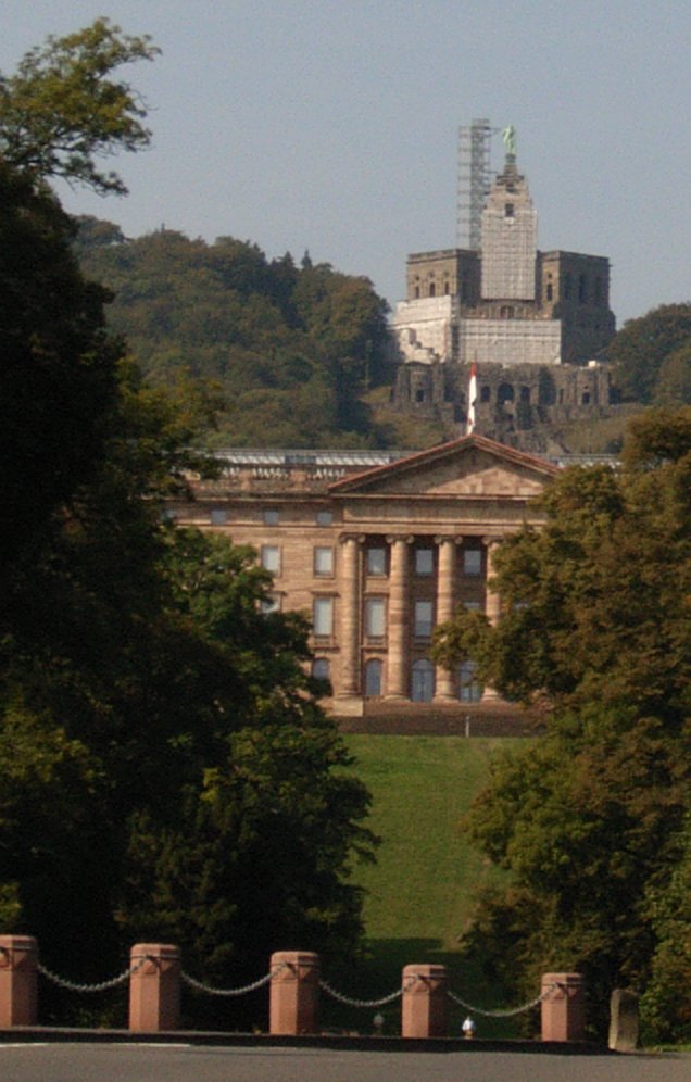 Herkules Aktuell. Ist noch mit einem Baugerüst versehen. Im Vordergrund ist das Schloss zu sehen. Darin befindet sich ein Kunstmuseum.