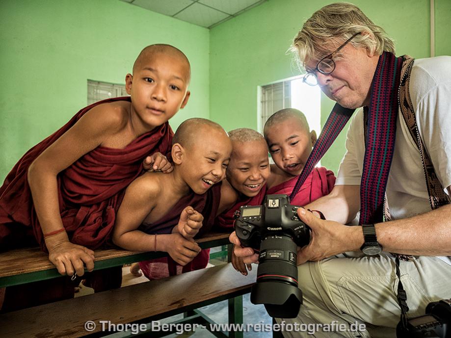 Interaktion eines Teilnehmers der Fotoreise mit jungen Mönchen in einer Schule, in der wir fotografiere durften