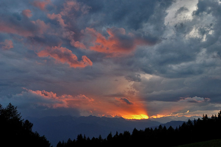Sonne hinter Bergen und Wolken