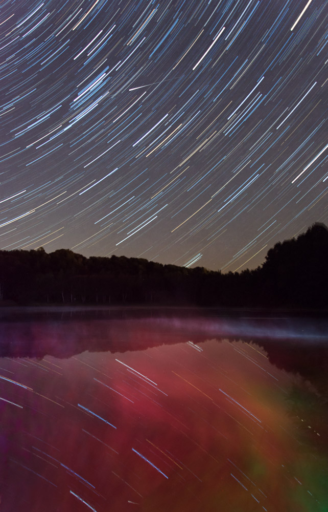 Sternschnuppe und Sternenbahnen überm Steinertsee bei Kassel 
aufgenommen im August in Richtung Osten, Startrails aus 126 Aufnahmen
