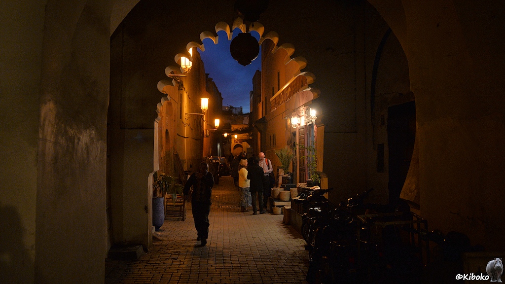 n einer engen Gasse sind Touristen und Einheimische zur blauen Stunde unterwegs