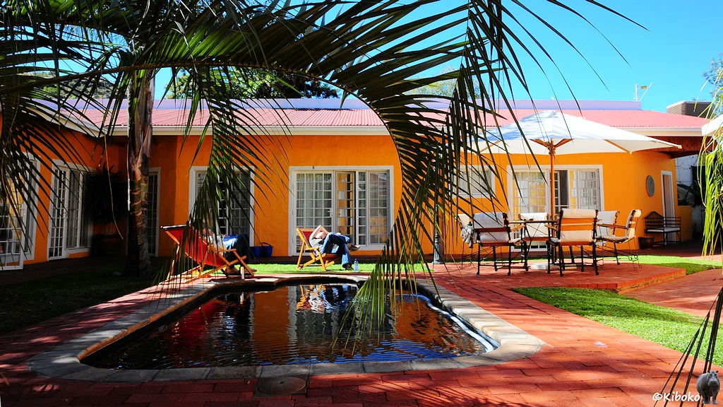 Kleines Schwimmbecken mit Liegesesseln und Palmen im Innenhof.