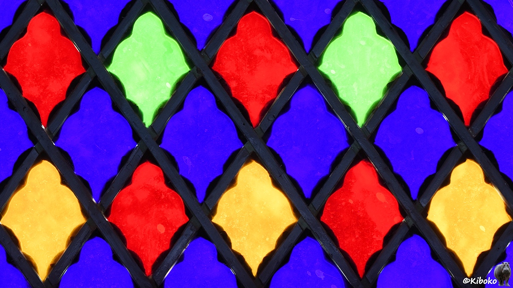 Buntes Fenster aus blauem, rotem, grünem und gelbem Glas.