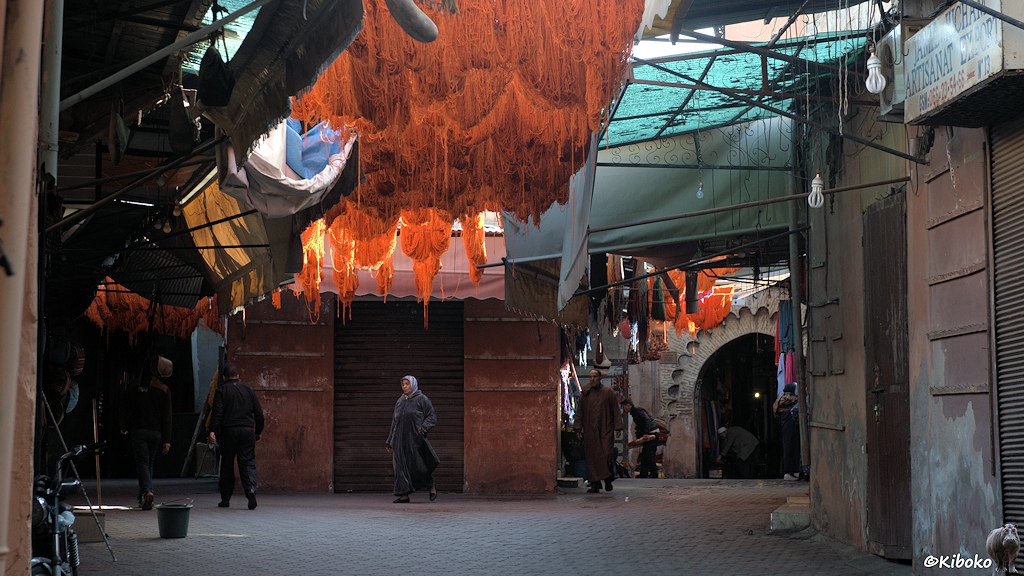 Wenige Menschen laufen morgens durch den Souk. Orange gefärbte Wolle hängt über der Gasse zum trocknen.