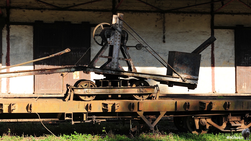 Das Bild zeigt einen zweiachsigen Kranwagen. Auf einem Farhgestell ist eine drehbare Plattform mit einem Bock mit großen Zanrad und Winde. Hinten ist auf der Plattfrom ein Gegengewicht. Vorne ist der Ausleger abgeknickt. Die Haltestangen für den Ausleger hängen lose in der Luft.